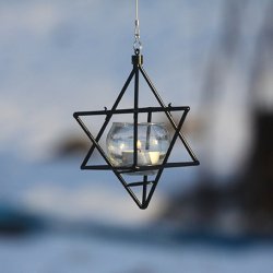 Sort stjerne i metal &#150; til fuglefodring eller som fyrfadslygte